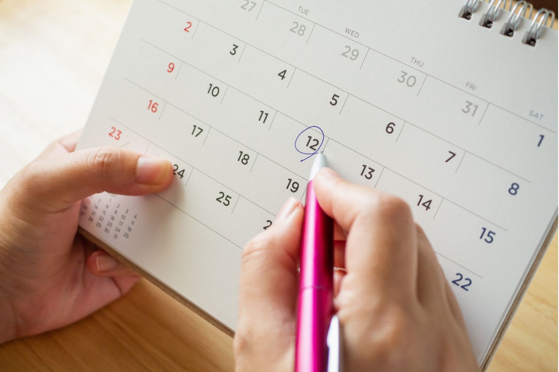 Person circling a date on a calendar