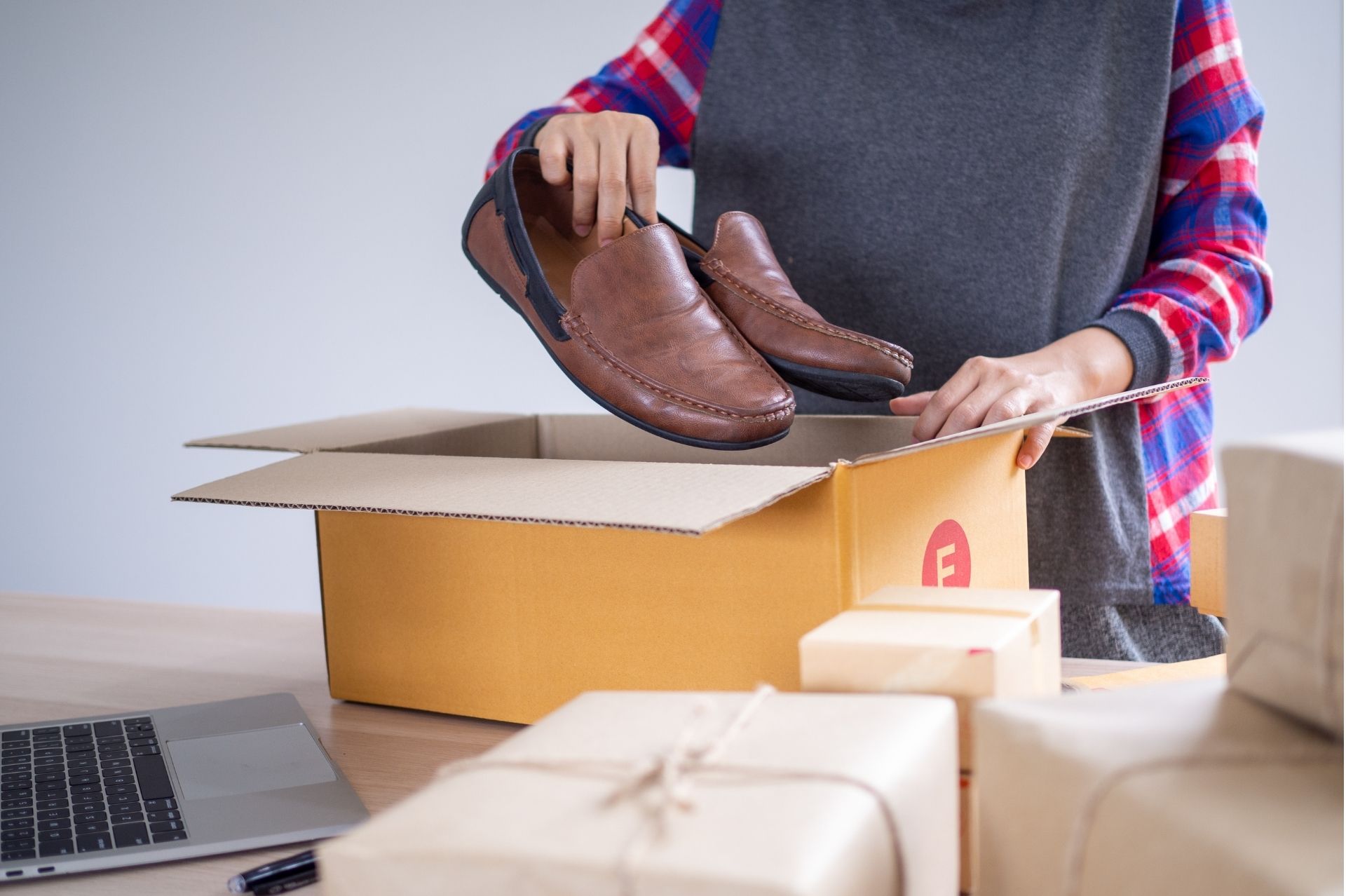 Person putting shoes into a packing box