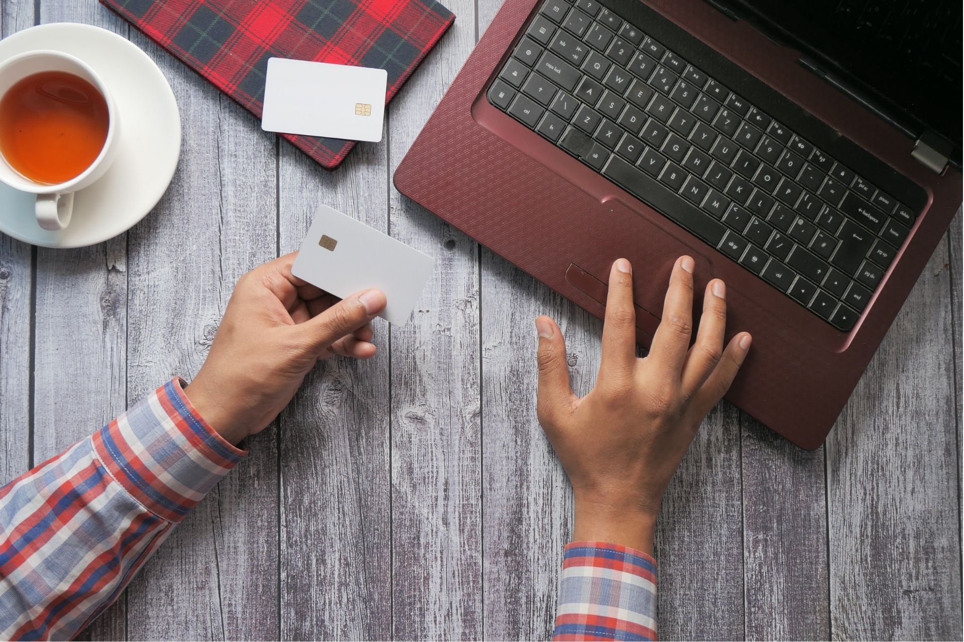 Person on a laptop holding a credit card